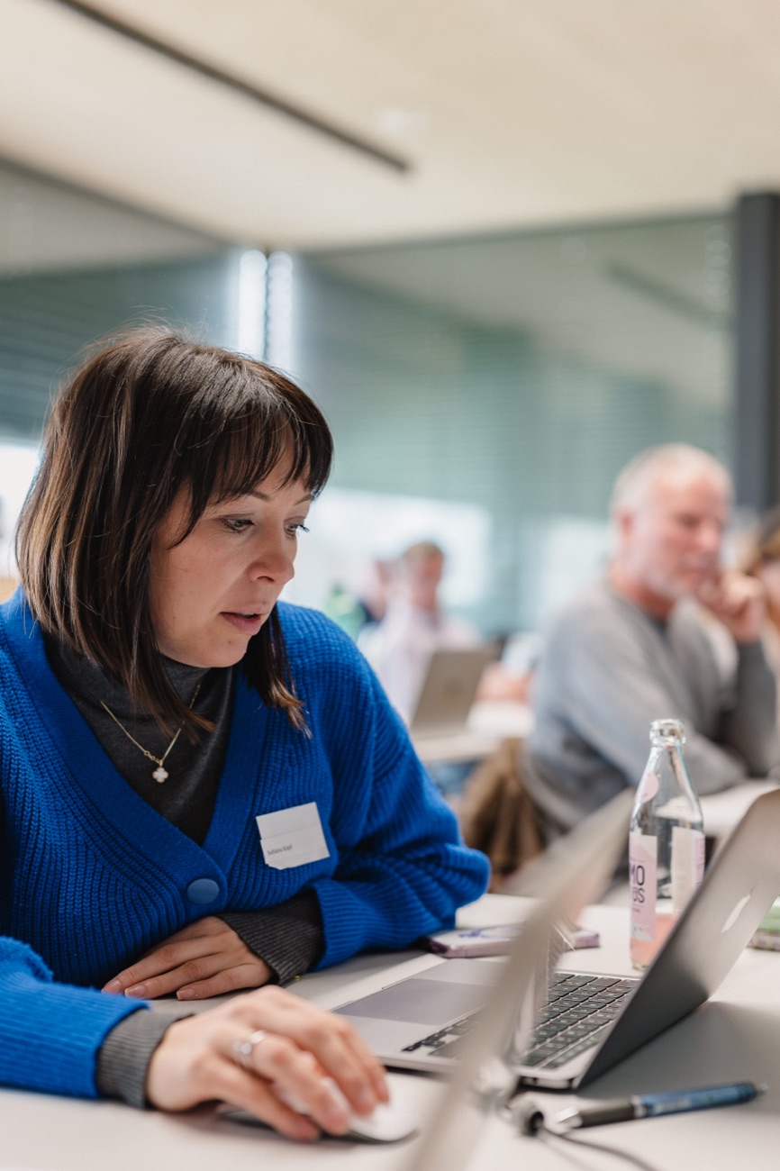 A participant works focused on her laptop at an ahead x workshop